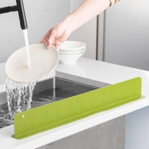 Flexible silicone sink splash guard with strong suction base attached to a kitchen sink