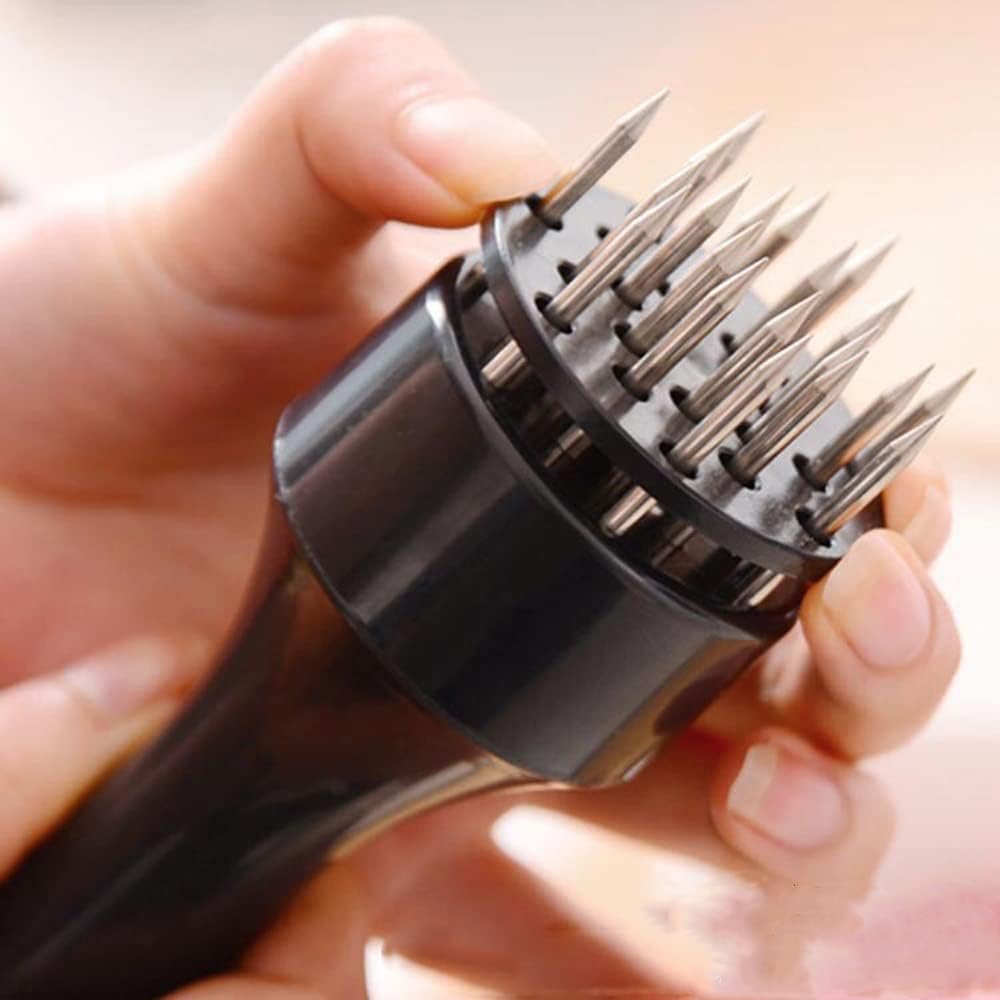 Stainless steel needle meat tenderizer being pressed into a fresh raw beef steak