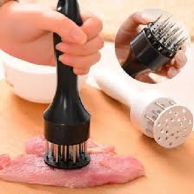 Stainless steel needle meat tenderizer being pressed into a fresh raw beef steak